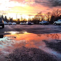 Cars on road against sky during sunset