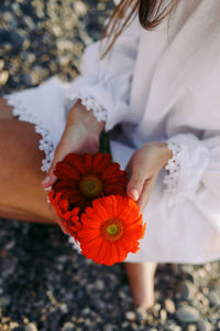 Midsection of woman holding flower