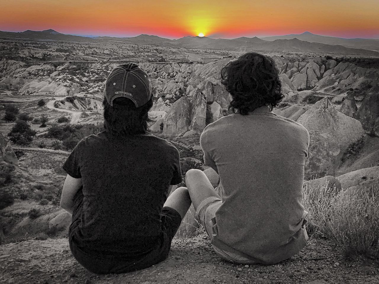 REAR VIEW OF MAN AND WOMAN LOOKING AT MOUNTAIN