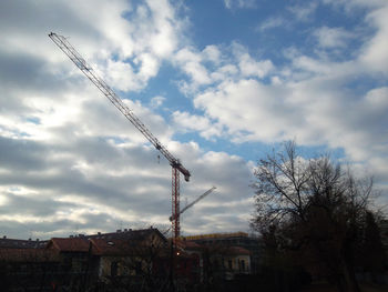 Low angle view of cranes against sky