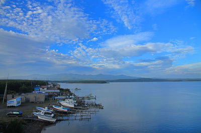 Boats moored in sea against blue sky