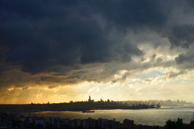 View of cityscape against cloudy sky
