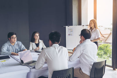 Businesswoman giving presentation to colleagues at office 