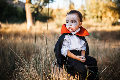 Full length of boy sitting on field