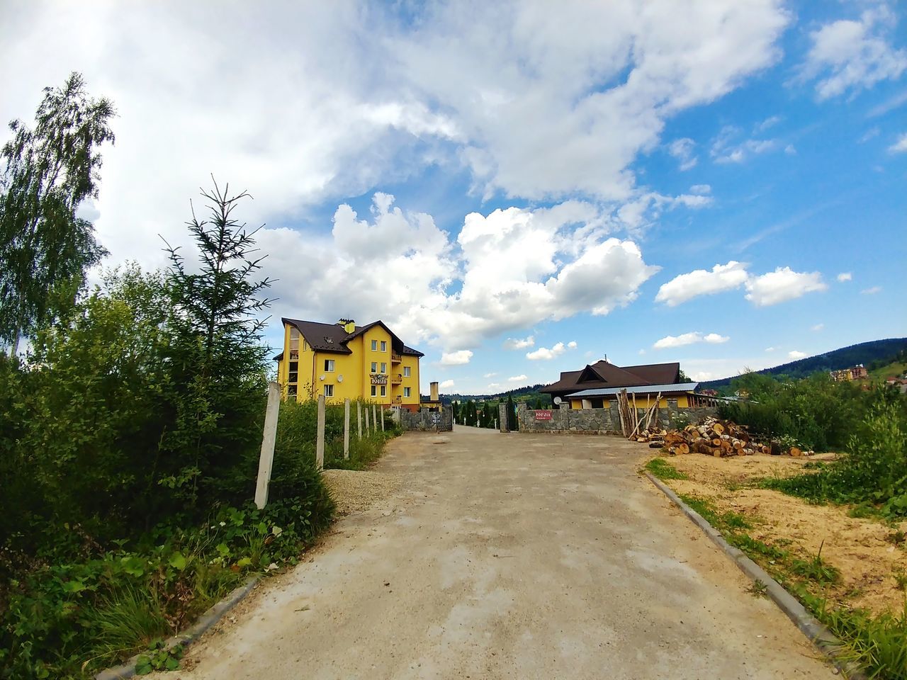 built structure, sky, architecture, cloud - sky, building exterior, building, plant, nature, direction, house, tree, the way forward, road, day, residential district, no people, land, outdoors, transportation, landscape