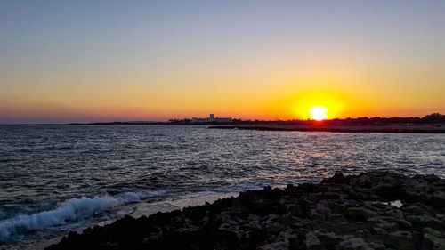 Scenic view of sea against clear sky during sunset