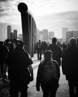 Rear view of people walking on street against buildings