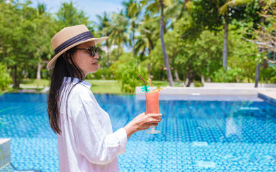 Young woman drinking water in swimming pool