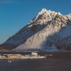 Scenic view of sea and snowcapped mountains against sky