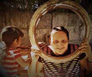 Portrait of smiling mother holding circular equipment by daughter