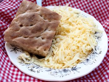 High angle view of shredded cheese with bread on table