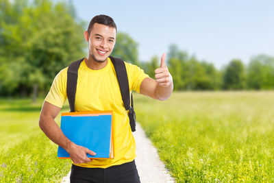 Smiling young woman standing on field