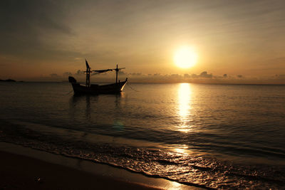 Silhouette boat in sea against sky during sunset