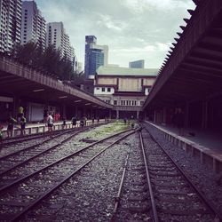 Railroad tracks in city against sky