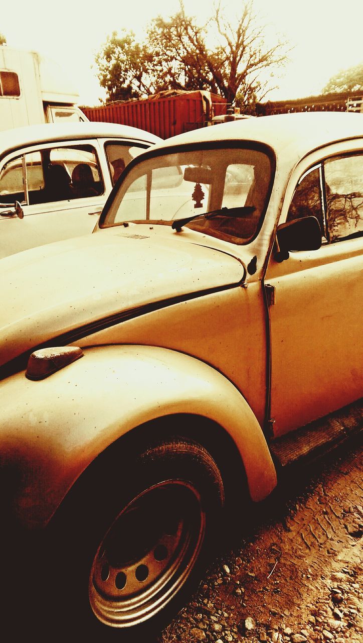 transportation, mode of transport, land vehicle, car, stationary, tree, part of, cropped, vintage car, travel, close-up, day, parking, parked, outdoors, side-view mirror, wheel, tire, no people, reflection