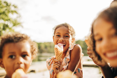 Happy girl eating ice cream with family on vacation