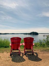 Lifeguard chair at beach against sky