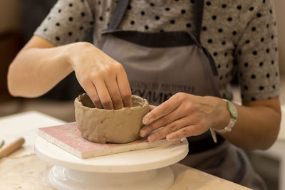 Female hands work with gray clay. hands make handmade clay products. ceramics.