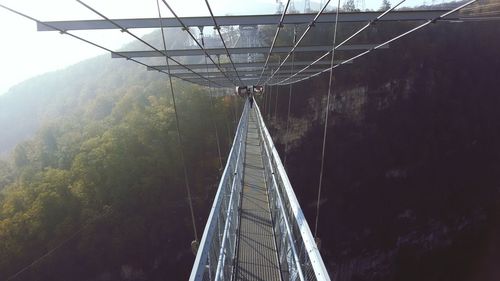 Footbridge against mountain at forest