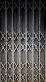 Full frame shot of metal fence against wall