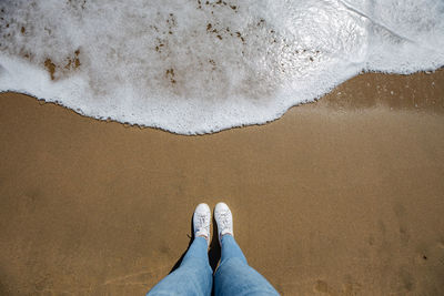 Low section of person standing on beach