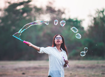 Young woman with bubble wand