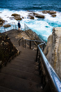 Rear view of man walking on steps