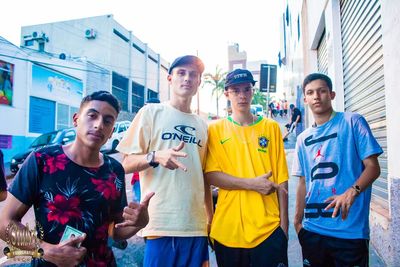 Portrait of young men standing against people