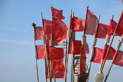 Low angle view of flags hanging against sky