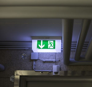 Low angle view of illuminated exit sign on ceiling