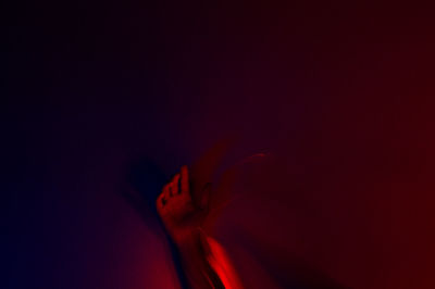 Close-up of hands against illuminated background