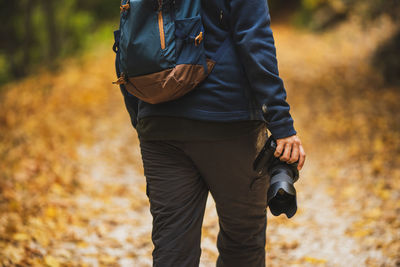 Midsection of man standing on field during autumn