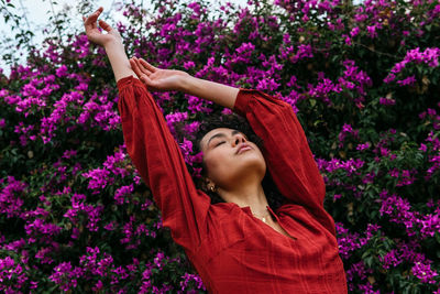 Low angle view of woman against purple flowering plants