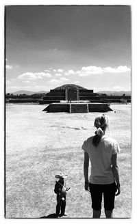 Silhouette of woman standing against cloudy sky