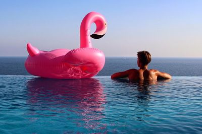 Rear view of people swimming in pool