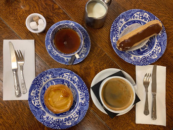 Tea or coffee break in traditional english tea house. eclair, pastries on porcelain. directly above