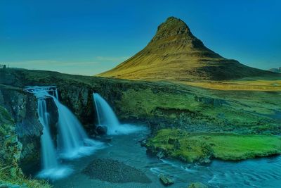 Scenic view of waterfall against sky