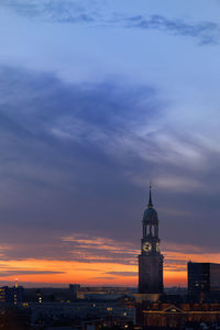 Buildings in city against sky at sunset