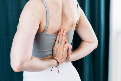 Midsection of woman standing against wall