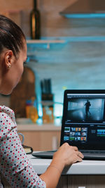 Side view of young woman using mobile phone at cafe