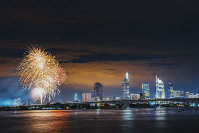 Firework display over illuminated buildings in city at night