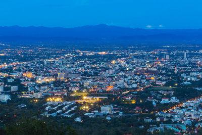 High angle view of illuminated cityscape against sky at dusk