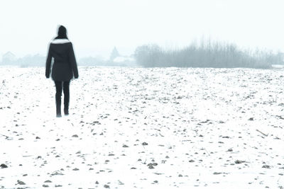 Rear view of man standing in snow