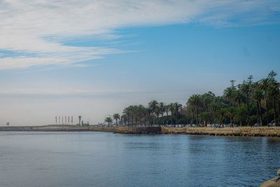 Scenic view of sea by buildings against sky