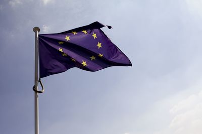 Low angle view of european union flag waving against sky