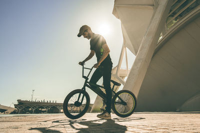 Man performing stunt on bicycle in city 