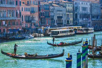 People on gondola in grand canal against buildings during sunny day
