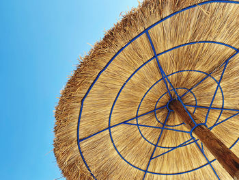 Low angle view of umbrella against clear blue sky