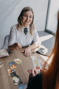 Portrait of a smiling young woman sitting on table