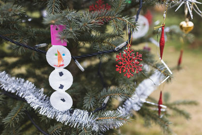 Handmade snowman decorations made of cosmetic cotton pads and paper on christmas tree outdoor. diy